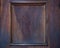 Discolored dark pale brown wooden plank with a center frame border from a door background
