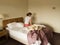 Disconsolate woman sitting on hotel bed