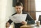 Discontented Office Worker Looking At Documents Sitting In Modern Office