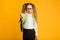 Discontented Schoolgirl Gesturing Thumbs Down Over Yellow Background