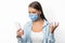 Discontented Woman Using Cellphone On White Background, Wearing Medical Mask