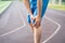 Diseases of the knee joint, bone fracture and inflammation, athletic man on a running track after workout suffering from pain in