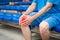 Diseases of the knee joint, bone fracture and inflammation, athletic man on a sports ground after workout suffering from pain in