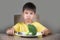 Disgusted child refusing to eat healthy green broccoli feeling upset in kid nutrition education on healthy fresh food and young