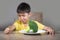 Disgusted child refusing to eat healthy green broccoli feeling upset in kid nutrition education on healthy fresh food and young