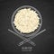 Dish of boiled white rice and chopsticks on grunge black chalkboard background. Top view.