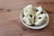 Dish of cherimoya fruit, Annona cherimola, aligned right, wood background