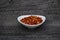 Dish of chillis or red pepper on a rustic wood background