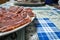 Dish of freshly sliced Iberian ham on blue tablecloth