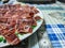 Dish of freshly sliced Iberian ham on blue tablecloth