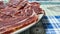 Dish of freshly sliced Iberian ham on blue tablecloth