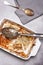 Dish of leftover pasta bake and cheesy garlic bread with a spoon and napkin