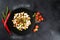 Dish of many pieces of lard with vegetables on black background