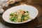 A dish of mixed fried steamed broccoli and carrot vegetables on a white plate