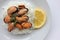 Dish with mussel risotto on white background. Top view of white rice with seafood and lemon slice. Copy space. Healthy eating