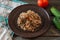 Dish plate of buckwheat porridge with carrots and meat. Fork, cucumber tomato