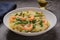 Dish of Tagliatelle with shrimps and green beans with grated Parmesan cheese on dark stone table. Pasta seafood. Mediterranean