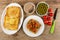 Dish with toasts, jar with meat pate, bowl with green peas, tomates, knife, sandwich with meat pate and tomato cherry in white