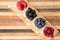 Dishes of fresh berries on decorative striped wood