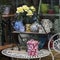 Dishes and a vase of flowers in the window of the hardware store, where you can buy different cozy things for decorating the house