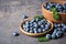 Dishware with juicy blueberries and green leaves