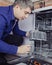 Dishwasher repair. A service center representative diagnoses and repairs a dishwashing machine at home. Specialist in working with