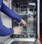 Dishwasher repair. A service center representative diagnoses and repairs a dishwashing machine at home. Specialist in working with