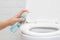 Disinfect, sanitize, hygiene care. people using alcohol spray on toilet seat lid and frequently touched area for cleaning