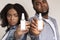 Disinfectant Spray Bottles In Hands Of Young African American Couple, Mockup