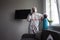 Disinfection of coronavirus in the apartment. People in protective suits make professional cleaning of the room from viruses and