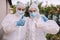 Disinfection service workers in hazmat suit with protective mask and protective glasses.