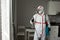 Disinfection worker in protective equipment against the background of the apartment, disinfection of the premises from viruses and