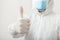 Disinfector or Doctor wearing protection suit and face mask showing thumbs up,positive gesture. Like to the end of pandemic