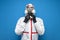 Disinfector man in a protective suit and a respirator on a blue isolated background, disinfection service worker, copy space