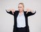 Dislike - portrait of beautiful plus size blonde woman in black business suit thumbs down over gray background