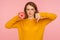Dislike to junk food. Portrait of displeased red hair girl in sweater showing thumbs down gesture and holding sweet donut