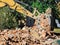 Dismantling a brick building with a bucket excavator