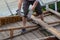 dismantling the roof. The worker removes old boards.