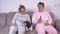 Dismayed woman and man in pajamas with dachshund puppy watch