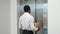 Dismissed black worker with dismissal box entering into the modern elevator