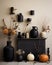 a display of black vases and pumpkins on