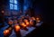 Display of candle lit carved halloween pumpkins in stone room with spider webs and eerie signs lit with blue and red light.