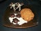 Display of Chocolate turtles and palm trees on a sugar beach with assorted cookies on a glass plate and black background