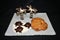 Display of Chocolate turtles and palm trees on a sugar beach with assorted cookies on a white glass plate and black background