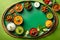 Display a colorful vegetarian thali against a green-toned backdrop with ample copy space
