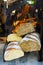 Display window of a bakery and pastry shop. Assortment of different kinds of freshly baked artisan bread rye whole wheat loaves