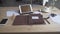 Display of work table desktop with tablet cell phone watch cup of hot coffee tea drink and leather case note pad journal