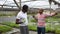 Displeased afro and latina male workers of plant nursery emotionaly talking
