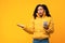 Displeased Black Woman Holding Smartphone Standing On Yellow Studio Background