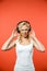 Displeased blonde woman listening music in headphones